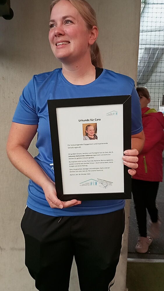 Caro Hoven lächelt in Fussballkleidung, sie hält eine Urkunde in der Hand.